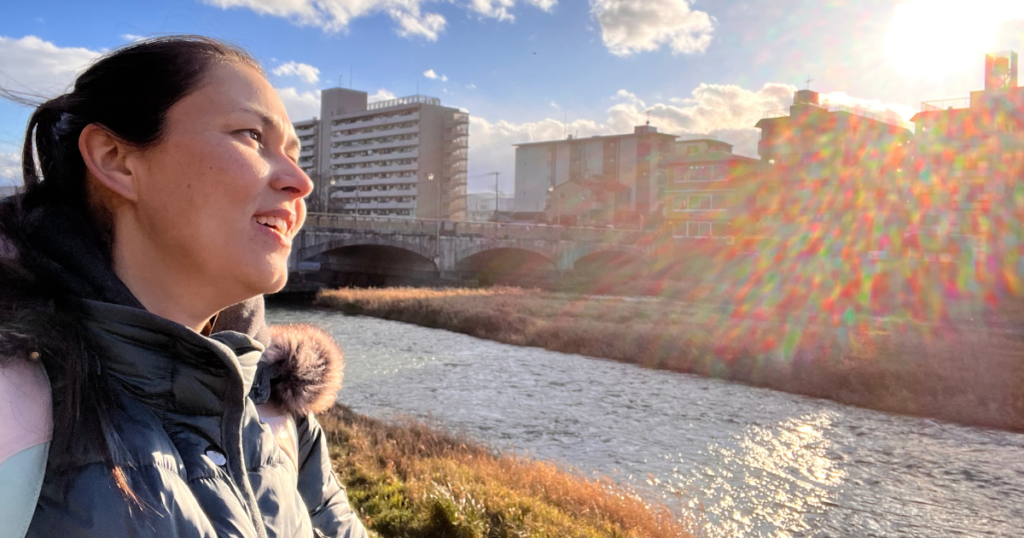 Ireen am Flußufer einer Stadt bei strahlendem Sonnenschein